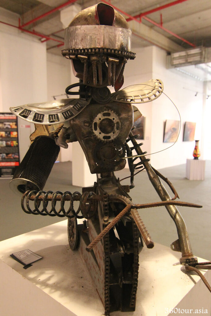 A metal sculpture of a robot made from scrape metal from a car.