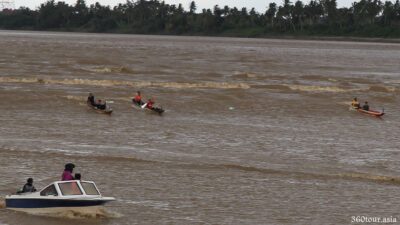 The double person row boat surfing along with the Tidal Bore.