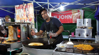 The owner of the stall selling Roti John. Thumbs up sir.