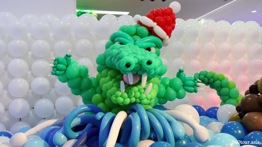 The crocodile balloon sculpture wearing a Christmas themed hat