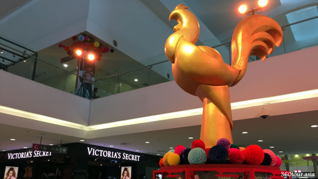 The Gold colored chicken replica standing proud among the shops