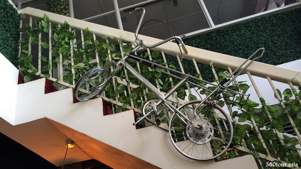 The hanging bicycle at the railing of the stairs