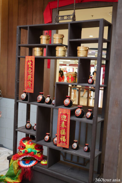 The traditional open cabinet with rows of rice barrel and Chinese wine bottles