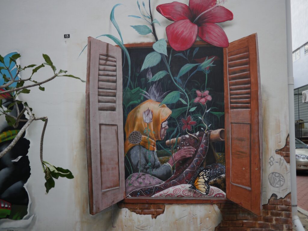 3D Mural of a local lady making a batik cloth by a open wooden window