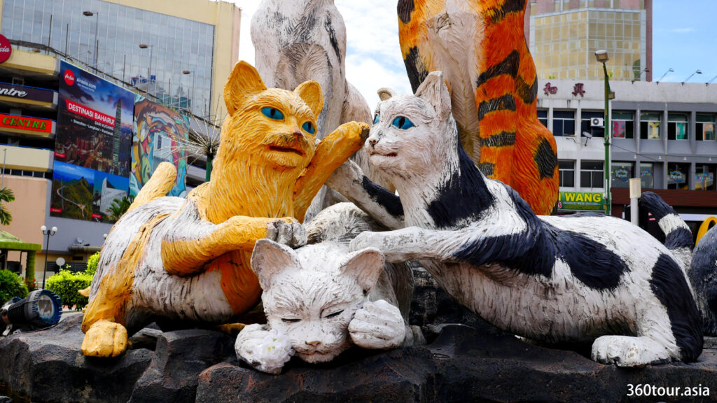 The cat statue features a group of playing cats.