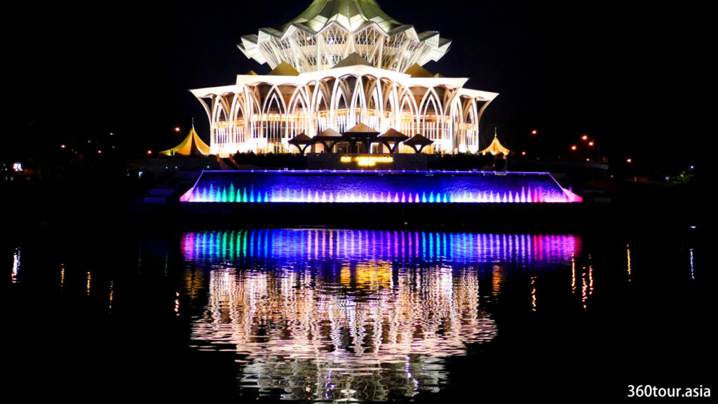 The reflection of the Colorful water fountain and Sarawak Legislative Assembly Building on the Sarawak River.