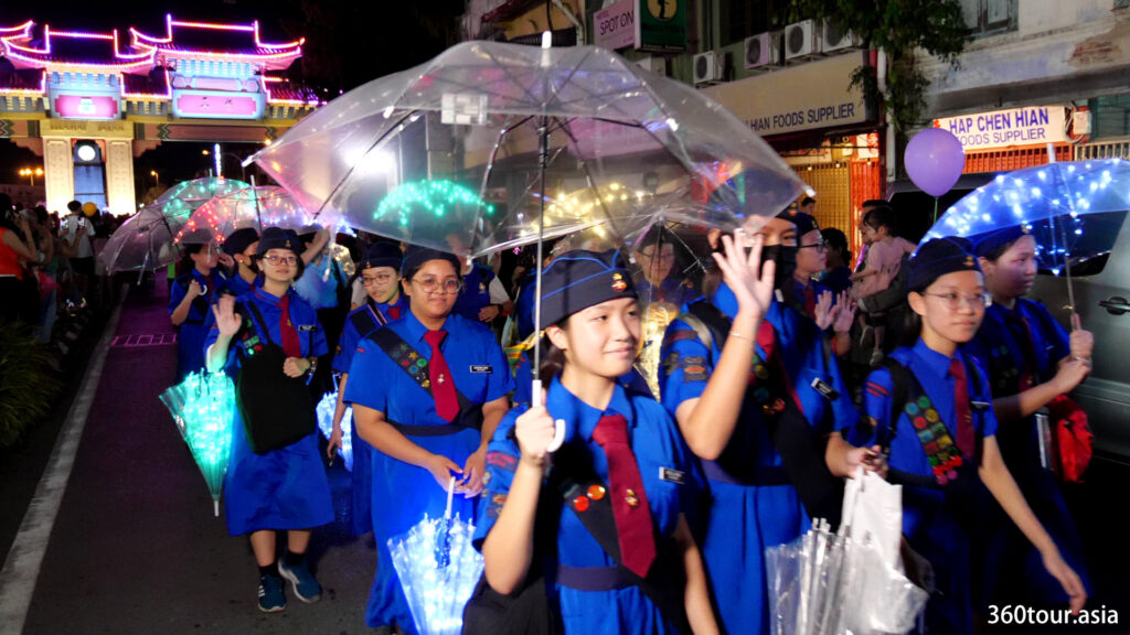 The girls brigade members holding the decorated umbrella with colorful LED lights.